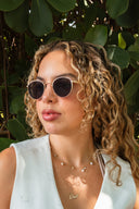 Woman wearing Varadero Capri round titanium sunglasses with dark tinted lenses