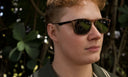 Person wearing sunglasses with a blurred natural background